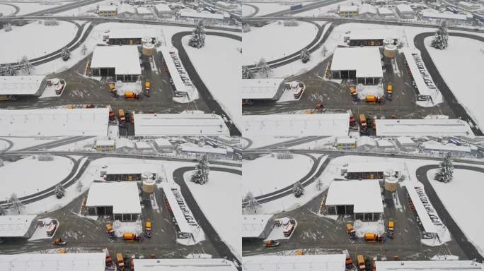 被雪覆盖的公路维修中心的扫雪车鸟瞰图