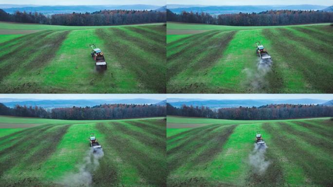 空中:拖拉机将肥料撒在农田的灰化土上，以提高产量