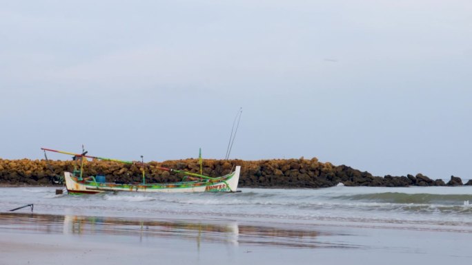 晴朗的天空，传统渔船漂浮在印尼马都拉岛的苏梅内普海岸。