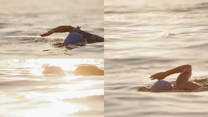 在日落时分，戴着帽子和护目镜在海洋中游泳的活跃女性的SLO镜头