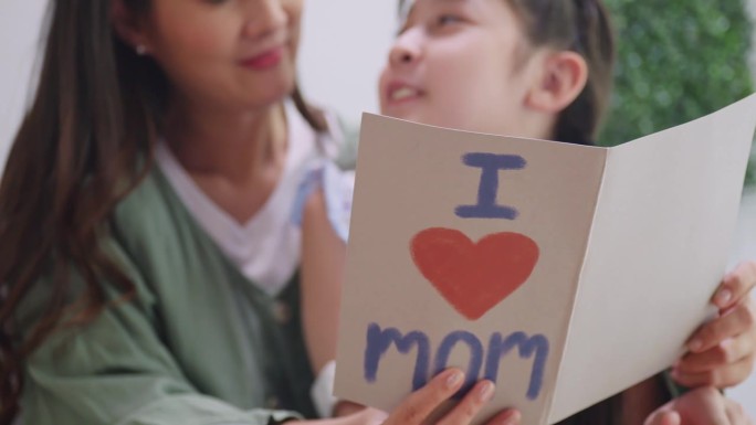一个小女儿给她亲爱的妈妈一张母亲节卡片。