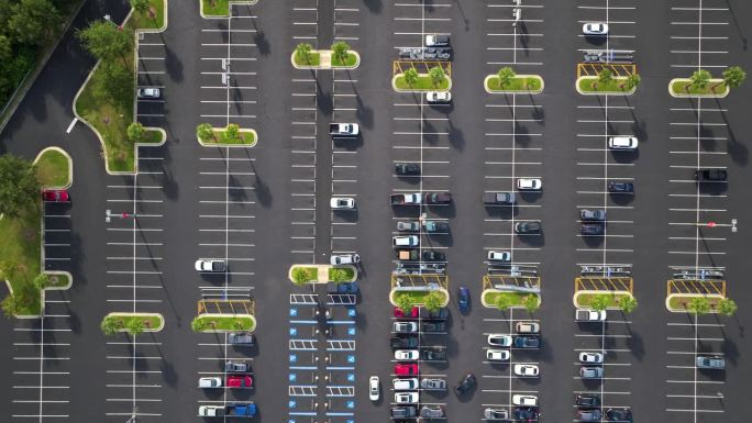 大停车场，停着很多车。超级购物中心的大型停车场，有车辆停放和方向的线条和标记