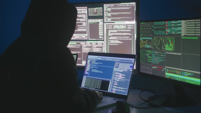 黑客或网络犯罪分子晚上坐在电脑前窃取网上信息的背影