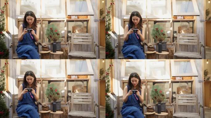 一名亚洲妇女坐在城里的一家商店里看着相机上的照片