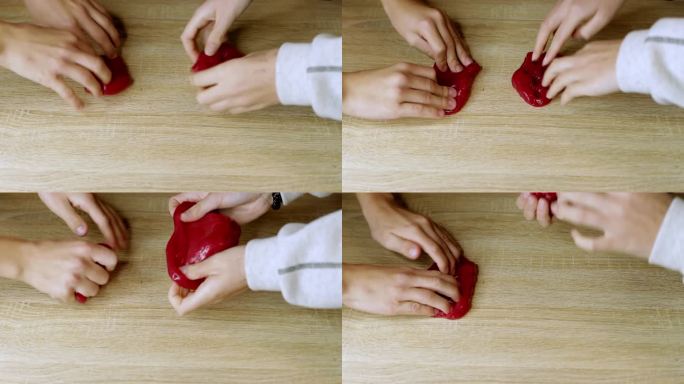 孩子们的手在玩滑溜溜的橡皮泥。孩子们的手在家里的桌子上玩着黏有弹性的橡胶泥。高品质4k画面