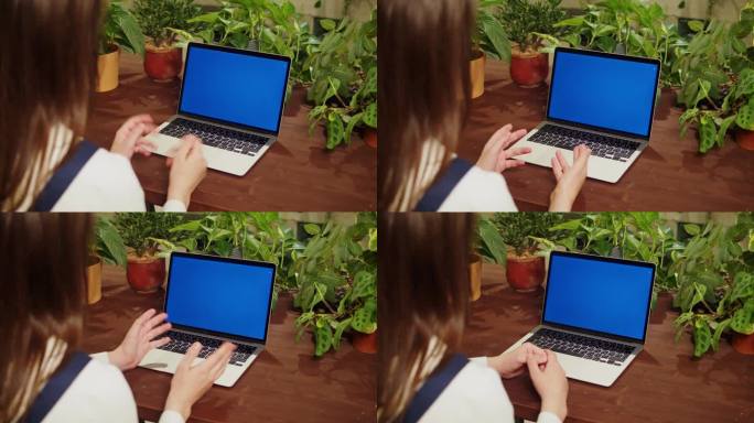 花店女用笔记本电脑视频通话，蓝色度键屏。有虚拟会议的温室工人，女植物学家，小企业主。园丁在花店，植物