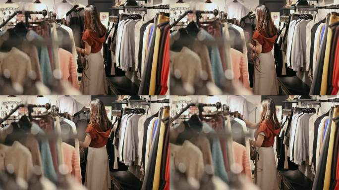 在日本大阪，一名日本妇女正在挑选冬季服装套装，并在时装店购物