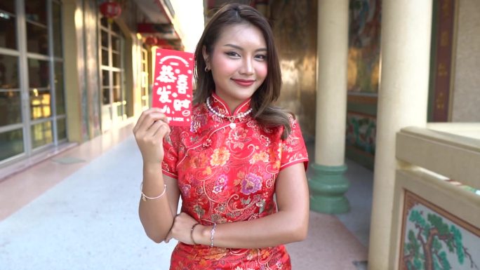 妇女穿红色旗袍庆祝中国新年。