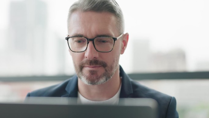 商务，阅读和成熟的男人在办公室戴眼镜的笔记本电脑规划，研究或电子邮件通信。面部，专注和冷静的男性ce