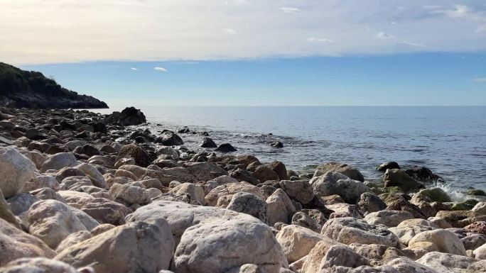 在一个阳光明媚的日子里，海浪在海石之间飞溅。