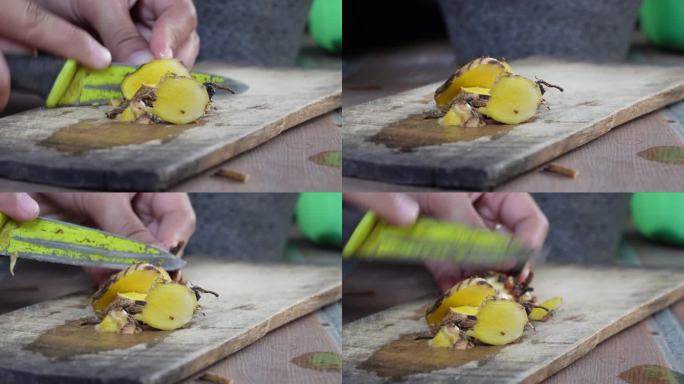这个女人在一块4k的木板上切新鲜的姜黄根。观赏鲜鲜鲜橙的根，用来制作金黄饱满的牛奶