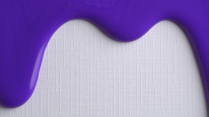 淡紫色的颜料滴在白纸上。宏观照片。紫色的油漆滴在白色的画布上与复制空间。