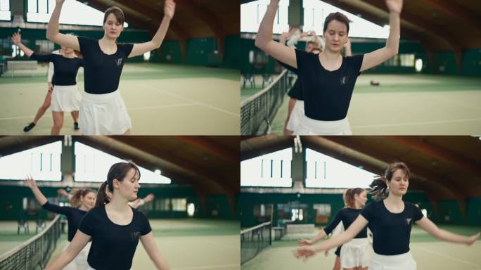 运动俱乐部网球场上，穿着运动服的活跃女青年边踏边做热身运动