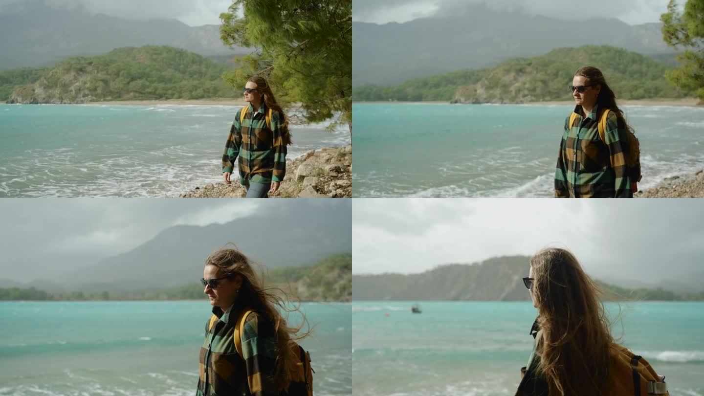 一个年轻女子独自旅行，自信地拥抱着海边的冒险，风吹乱了她的头发。秋天的天气凉爽，阳光照亮了她。缓慢的