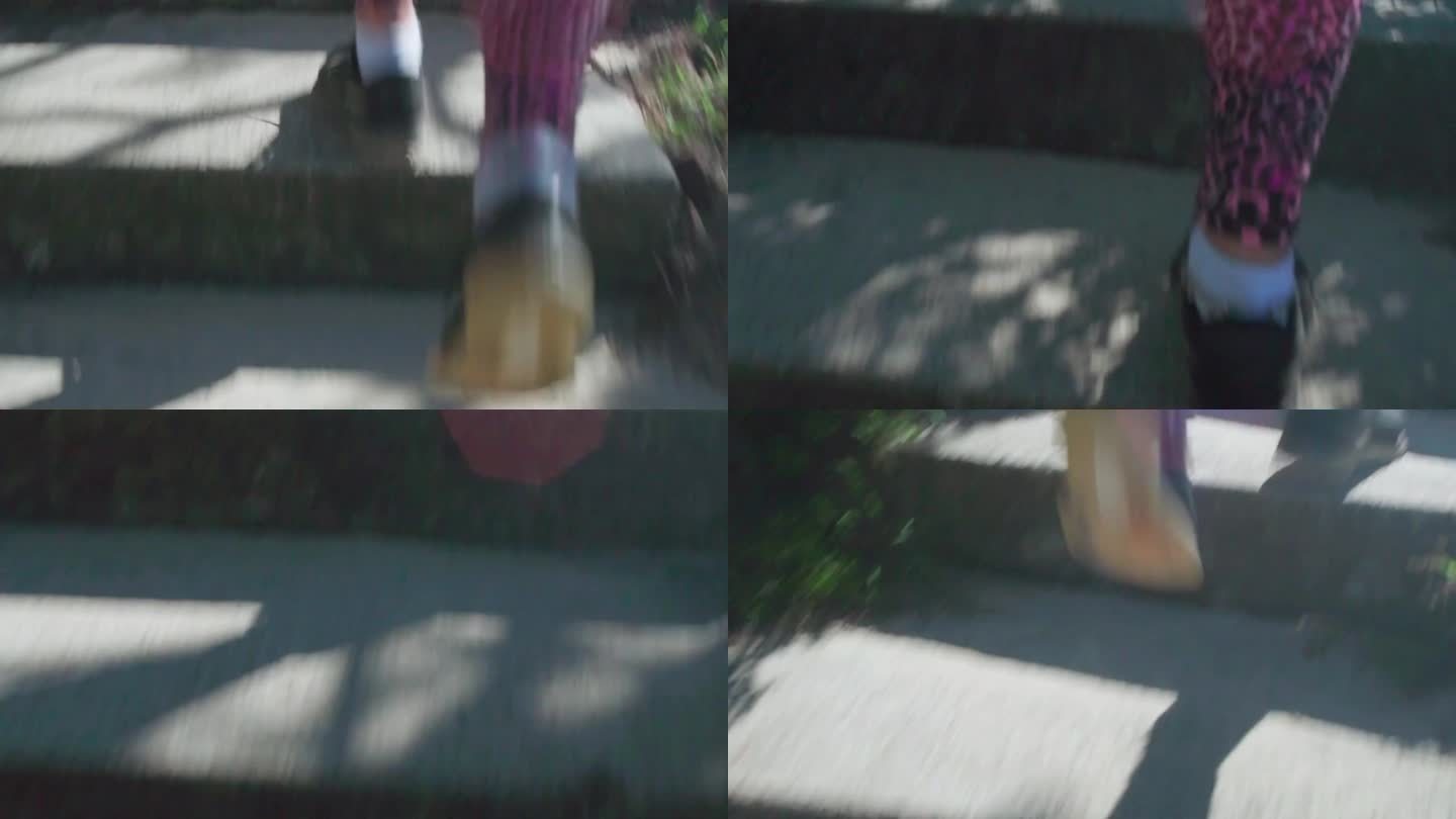 一个跑动者在室外楼梯上的云台镜头，近距离拍摄。楼梯在部分阳光下，穿着粉色打底裤和跑鞋的跑步者引领着观