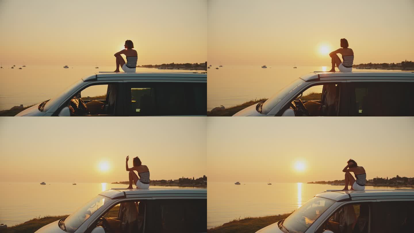 在日落的时候，女人坐在海边的露营车上，对着天空