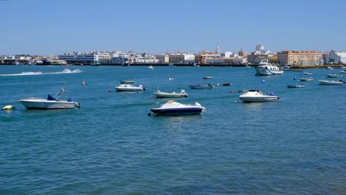 2023年8月14日，西班牙韦尔瓦的克里斯蒂娜岛:渔船在克里斯蒂娜岛开曼岬海滩前的海面上航行