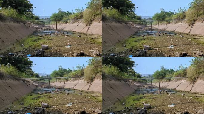 放眼望去，一条巨大的灌溉渠干涸了，里面堆满了垃圾、垃圾和垃圾