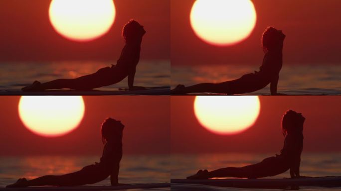 宁静的女人练习瑜伽在海上冲浪板在日落时的慢镜头