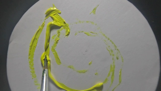 艺术家笔刷的俯视图，在旋转的白色桌子上散布黄色，背景模糊