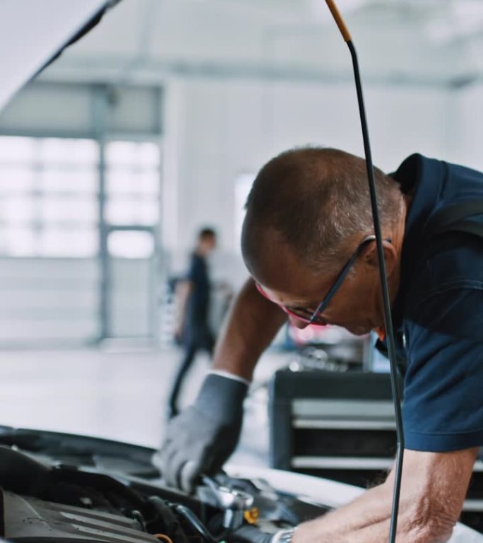 男机械师在汽车修理店修理汽车发动机
