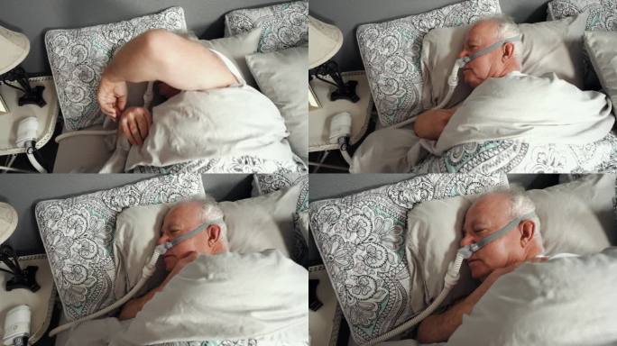 成年男子在被诊断患有睡眠呼吸暂停后使用CPAP(持续气道正压通气)机睡觉