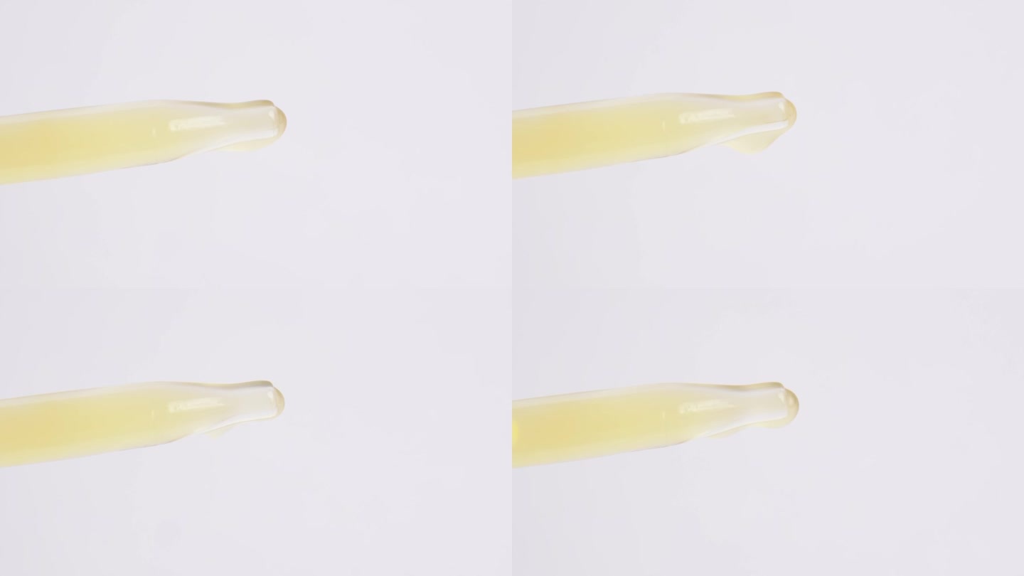 一滴黄色血清从玻璃移液管中落下，近距离观察。油提取物从玻璃移液管中滴下