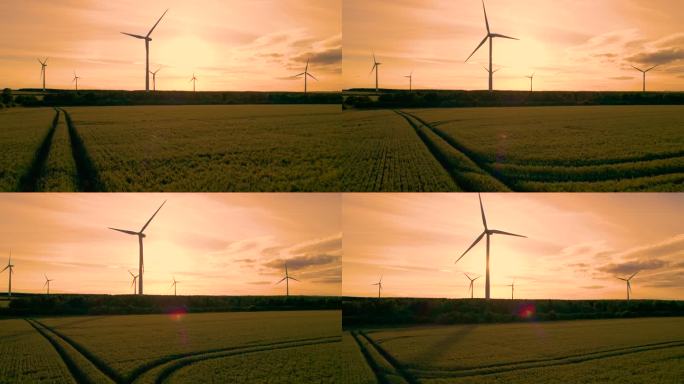 航拍，剪影:金色的日出与现代风车在田野上升起