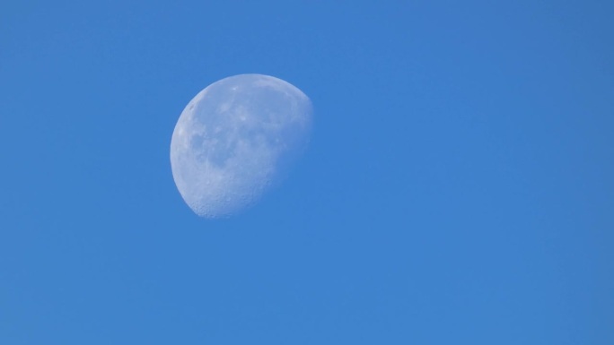 蓝蓝的天空上，月亏时的月亮特写
