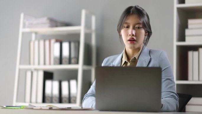 长期坐在办公室的亚洲女性正遭受着身体和肩膀疼痛的折磨。在办公室用笔记本电脑工作的女商人，在休息或下班