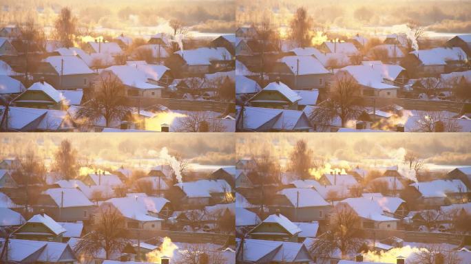 在一个寒冷的冬日早晨，在太阳的映衬下，烟囱里冒出橙色的烟雾，白雪覆盖的村庄房屋。美丽的冬季大自然。时