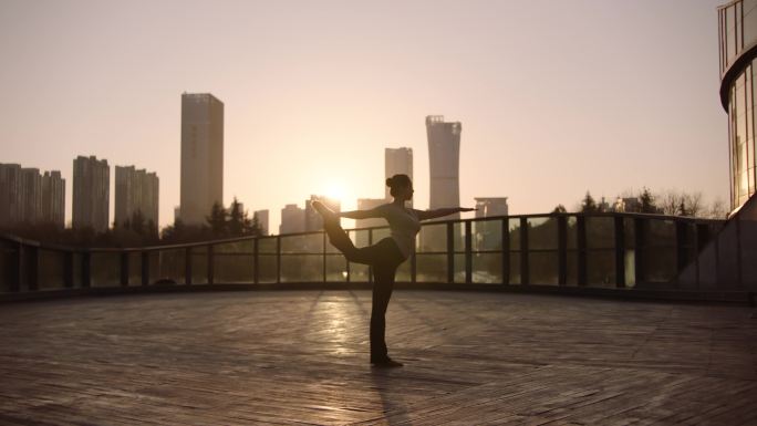 阿莱拍摄城市夕阳下女人做瑜伽健身运动