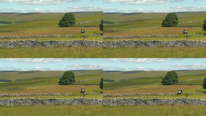 在美丽的英国乡村，用拖拉机在石墙牧场上割草