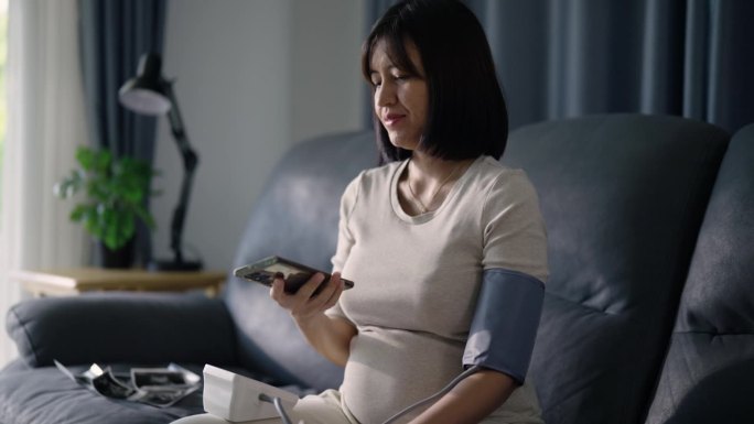 一位年轻的孕妇在家里测量自己测的血压。
