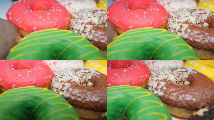 一堆不同口味的彩色甜甜圈。跟踪拍摄。