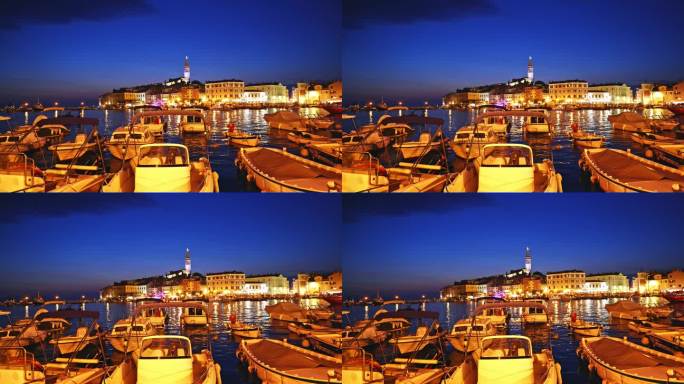 船只停泊在港口在照亮的老城蓝天在黄昏。罗维尼，伊斯特拉，克罗地亚。