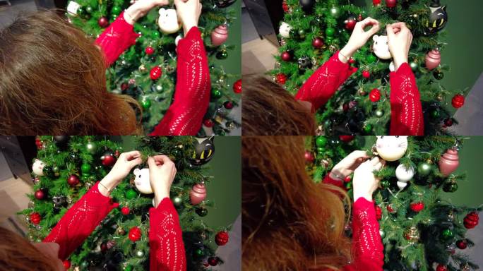 一个穿着红色衣服的女孩正在装饰圣诞树