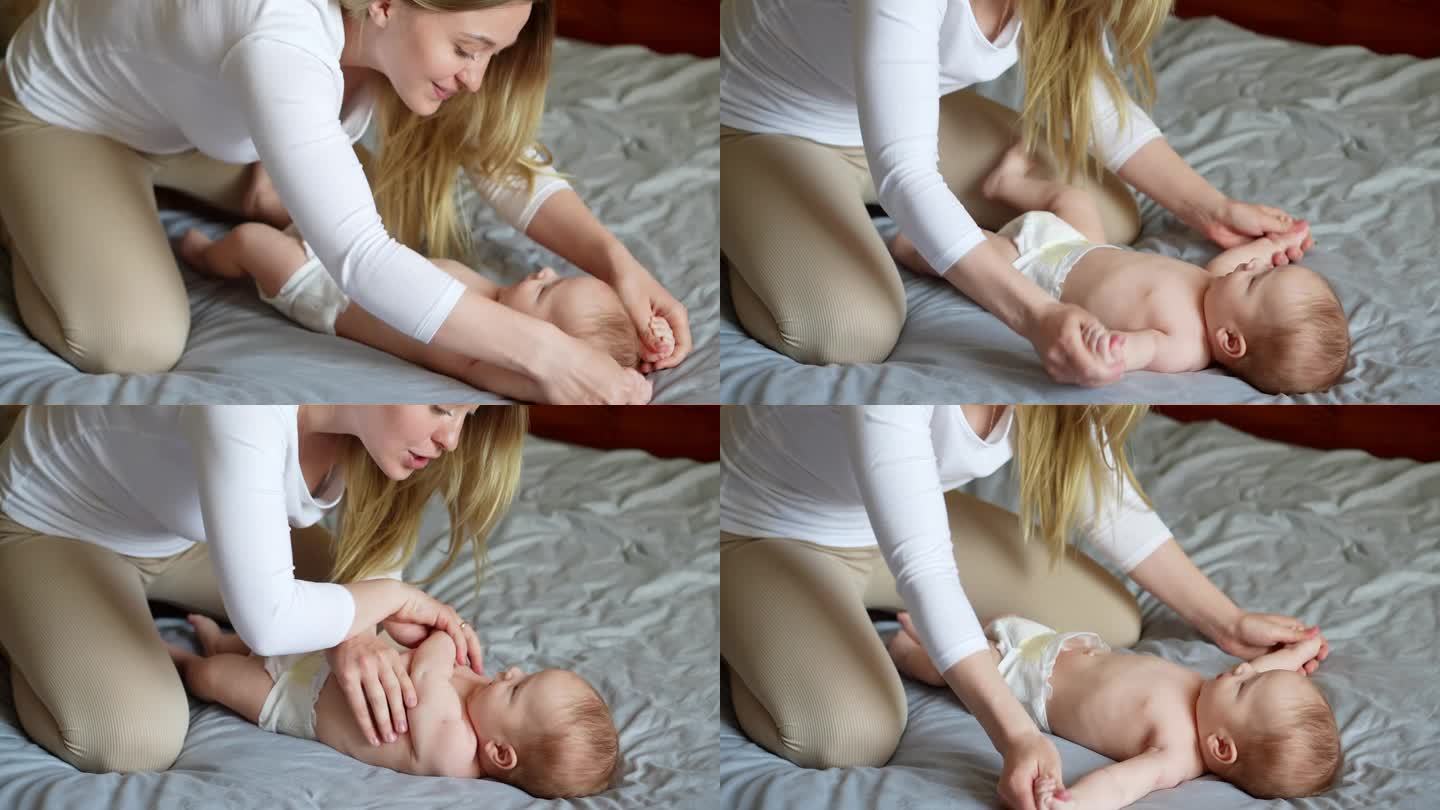 妈妈给宝宝做一个练习，手臂的弯曲和伸展。照顾孩子，产假，按摩师。