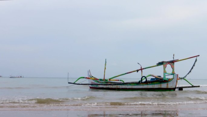 晴朗的天空，传统渔船漂浮在印尼马都拉岛的苏梅内普海岸。