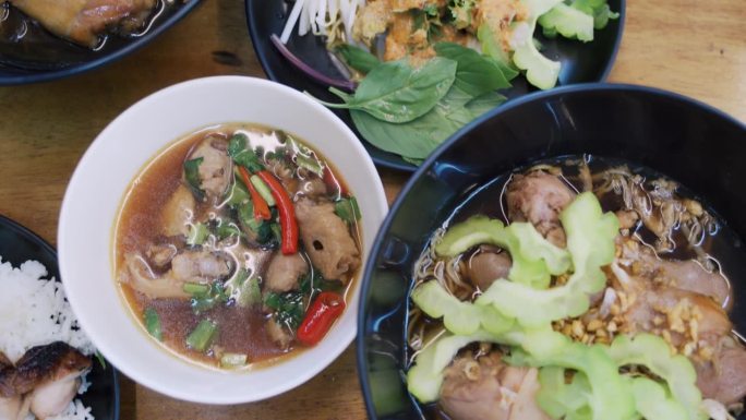 在餐馆里，女人喜欢在自助面条上舀鸡肉和苦瓜泰国菜。