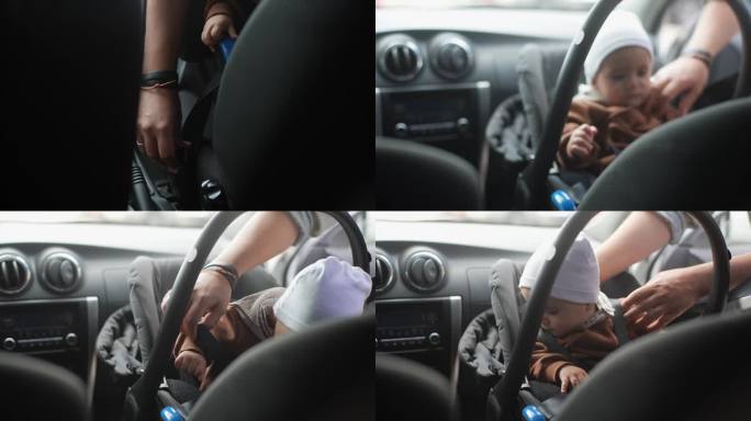 特写:无法辨认的女性双手系紧婴儿安全带，男婴坐在前座背对引擎。车内系着安全带的可爱孩子。