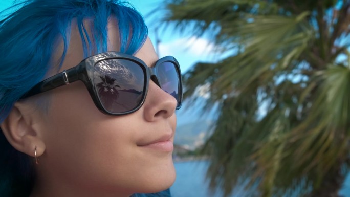 海岸边蓝头发的快乐少年。