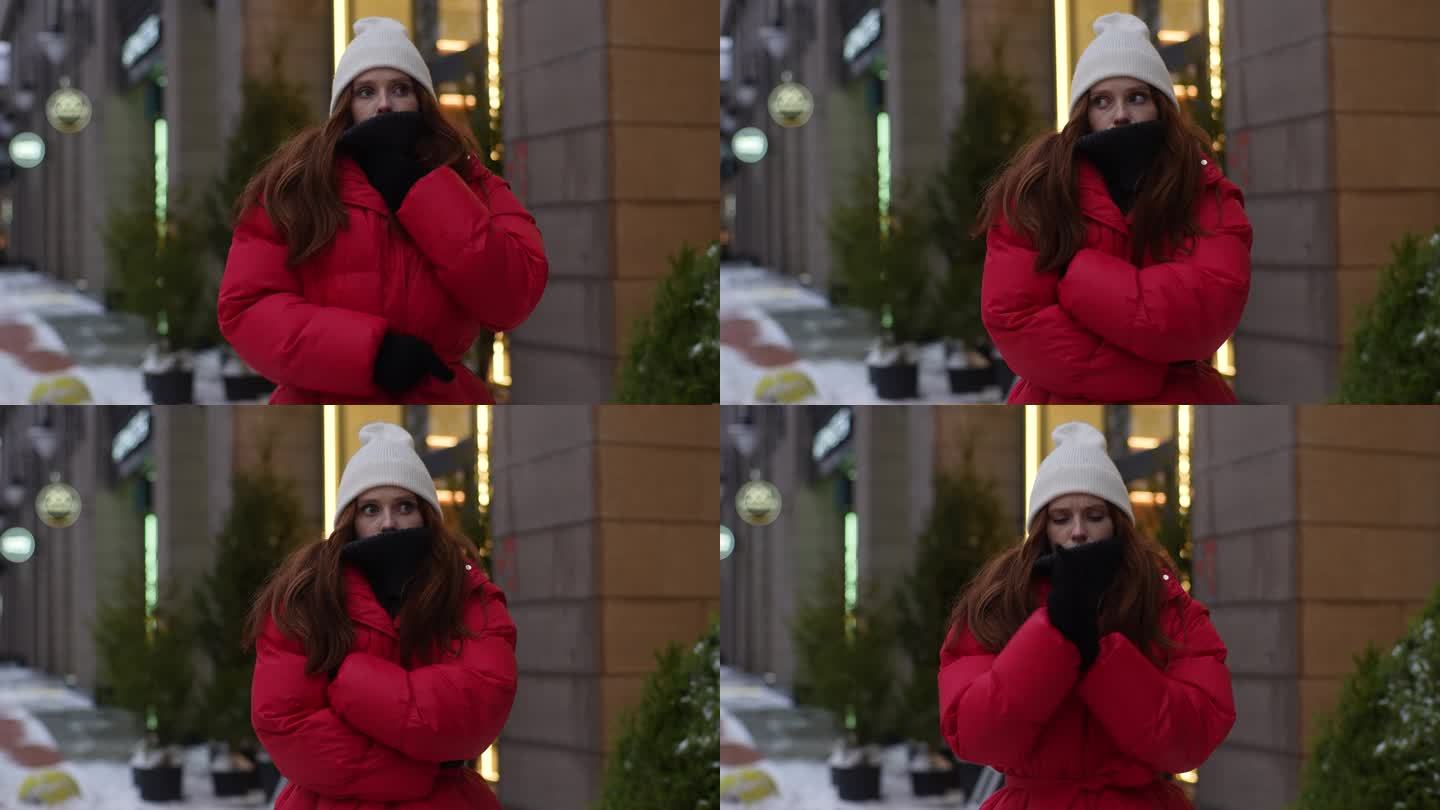 中景:在寒冷的大风天气里，穿着冬装的漂亮女子在城市街道上等出租车，她搓着手，吹着手掌取暖