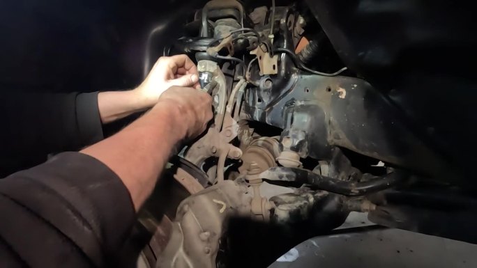 汽车修理在车库的底盘上，在光线不足的恶劣和紧急的条件下