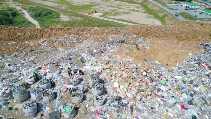 鸟瞰图大型垃圾填埋场、垃圾场。成群的鸟在垃圾堆上空盘旋。生态问题，自然污染。污染和过度消费的观念。