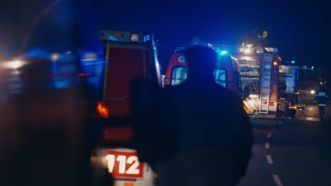 夜间在紧急地点的消防队员和消防车救援队
