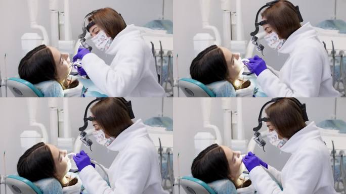 一位年轻女子正在一家现代化的牙科诊所接受治疗。牙科治疗的概念，美白，安装贴面和牙套，清洁口腔。