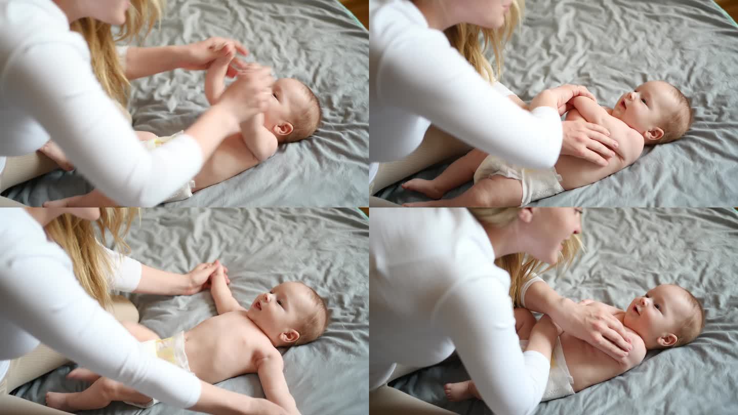 妈妈给宝宝做一个练习，手臂的弯曲和伸展。照顾孩子，产假，按摩师。