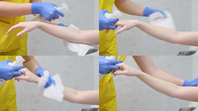 黄色手套，带着蓝色的手指，在人的手臂上涂乳液