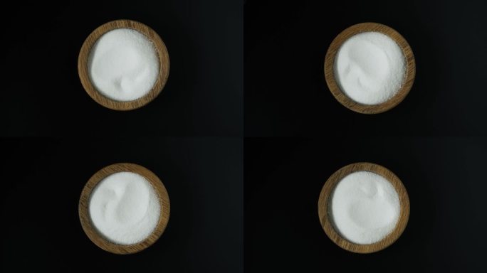木碗中的食品添加剂E575，俯视图。葡萄糖- δ内酯，也称为葡萄糖内酯。纯GDL，白色无臭结晶粉末。